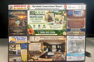 A collection of local business advertisements arranged in a grid layout on a bulletin board